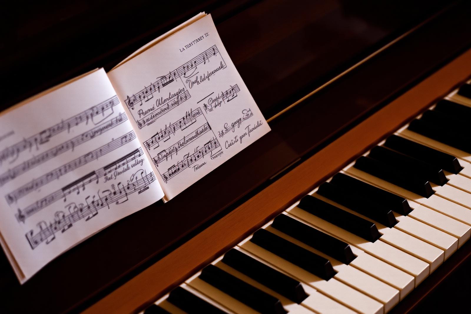 Handwritten manuscript resting on a piano in low warm light